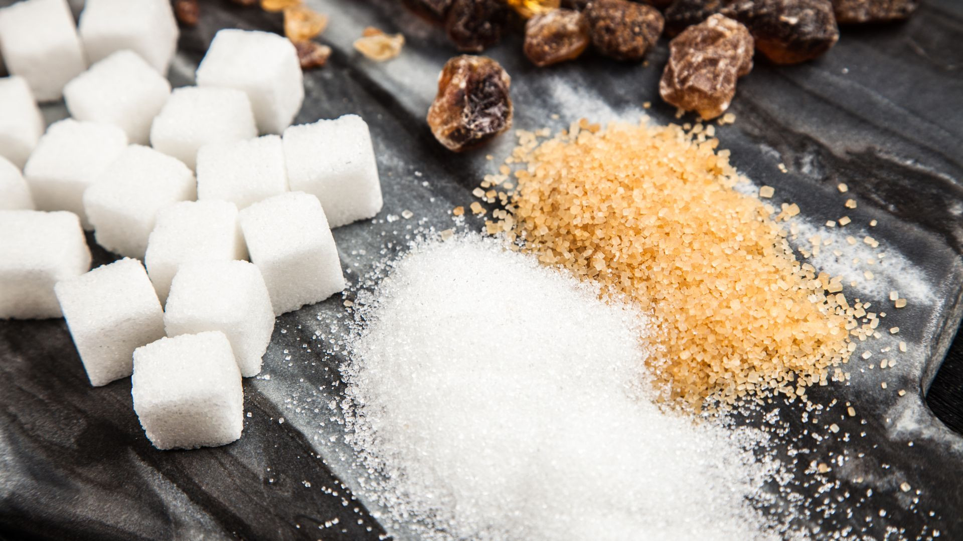 Illustrative arrangement of white sugar cubes and crystals with brown sugar