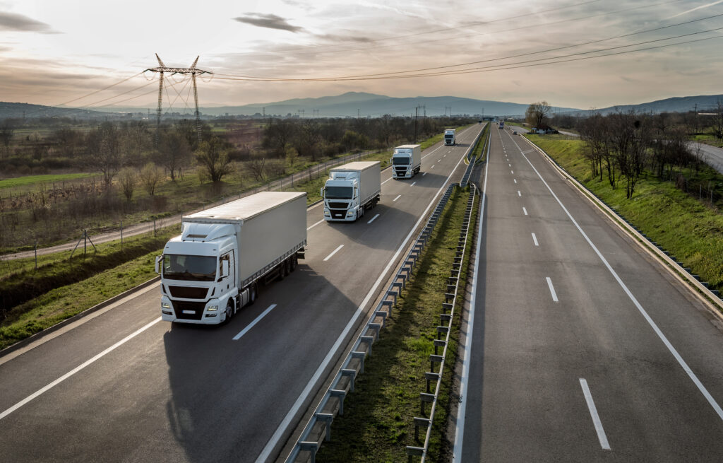 Large trucks traveling together on a highway